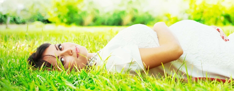 Pregnant woman lying in the grass