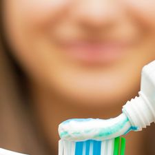 Woman applying toothpaste to her brush