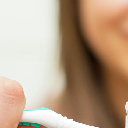 Woman applying toothpaste to her brush