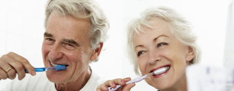 Older couple brushing their teeth