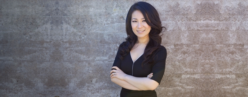 Dr. Stella Kim standing against a grey background