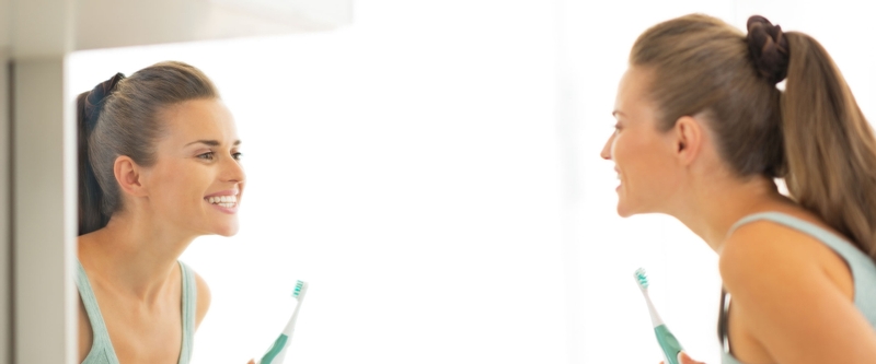 young woman brushing her teeth